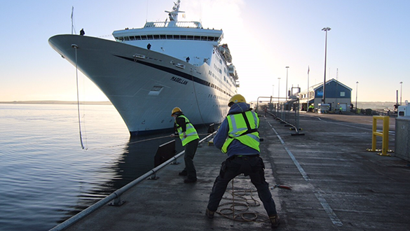 WORKERS WORKING ON PULLING THE ANCHOR OF A SHIP IN A MARINA